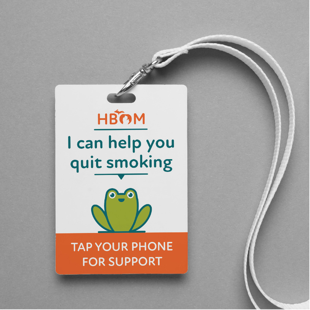 plastic card with lanyard attached. Card has HBOM logo with text I can help you quit smoking. Tap your phone for support with cheerful frog