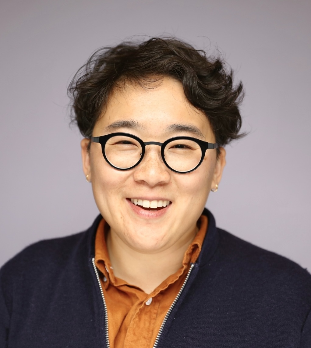 noa kim headshot copy Noa Kim smiling wearing glasses and checkered shirt